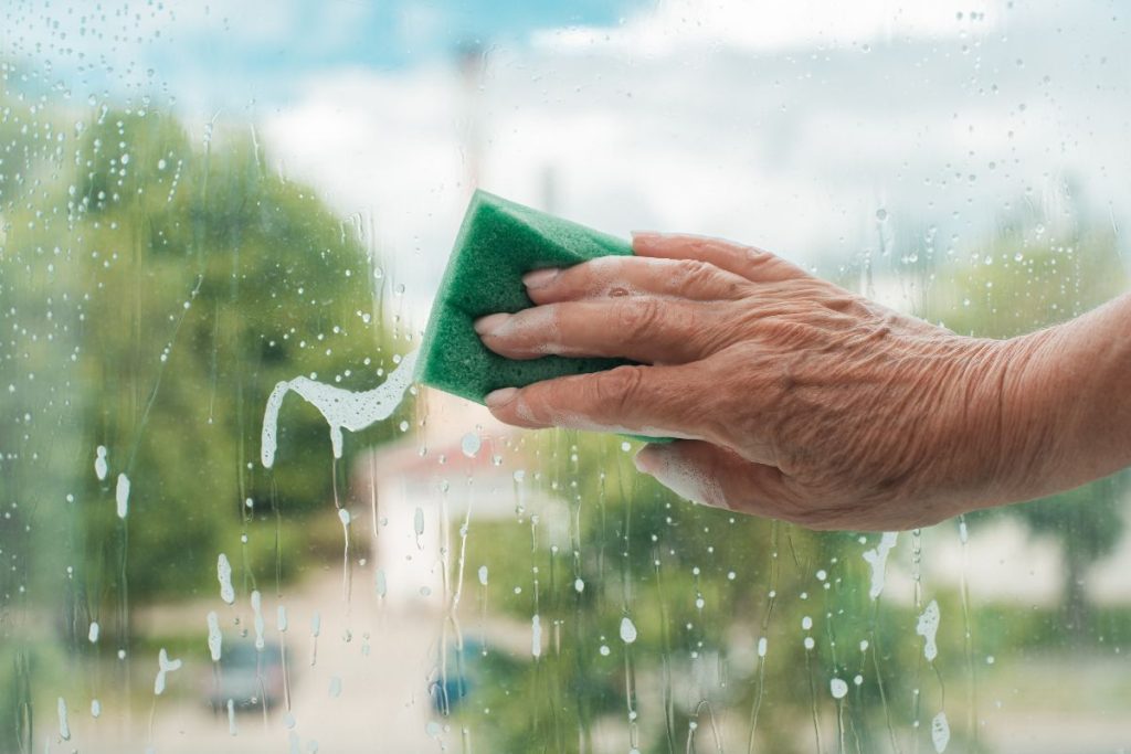 cleaning a wet window with a sponge
